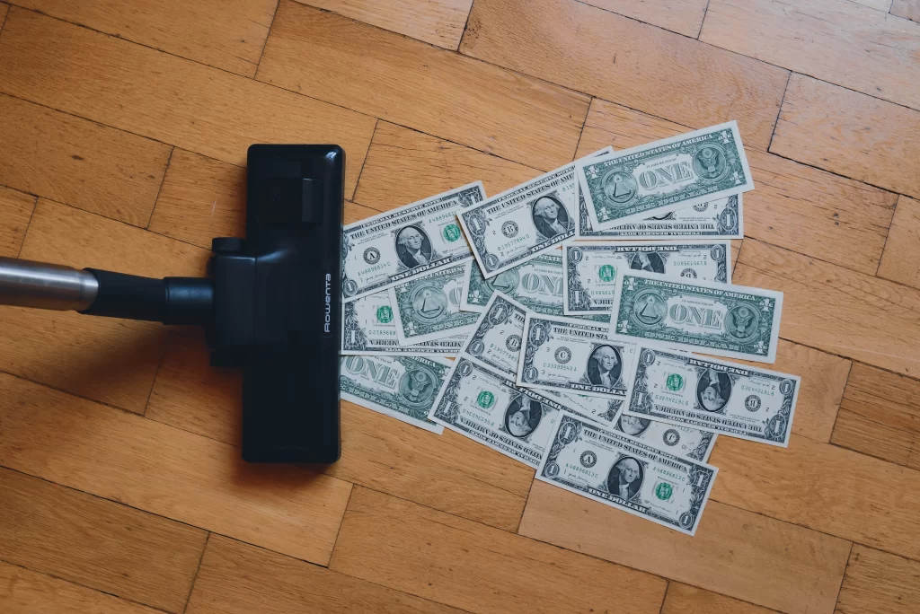 picture of vacuum sucking up money symbolizing how debt sucks up your disposable income, it sucks